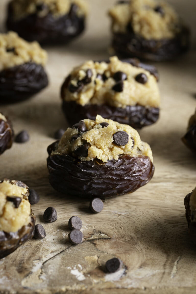cookie dough stuffed dates on a wooden cutting board.
