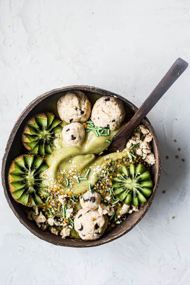 matcha kiwi nice cream bowl in a coconut bowl with a wooden spoon from coconut bowls