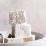 square vegan marshmallows stacked on top of one another in a bowl