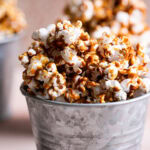 a close up shot of one of the buckets of caramel popcorn