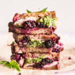 vertical image of vegan blackberry pesto grilled cheese sandwich stacked on top of one another