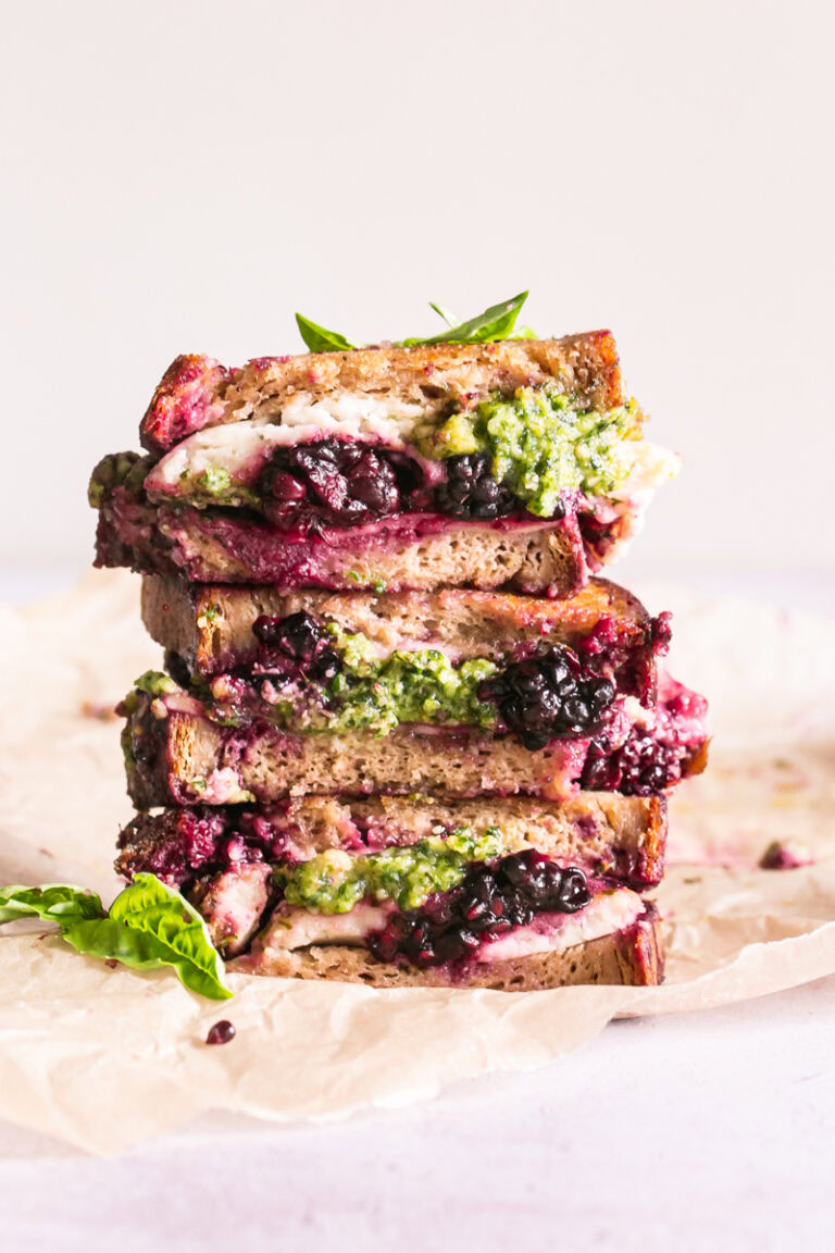 vertical image of vegan blackberry pesto grilled cheese sandwich stacked on top of one another