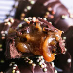 a close up of a chocolate egg with a bit taken out of it to show the caramel filling