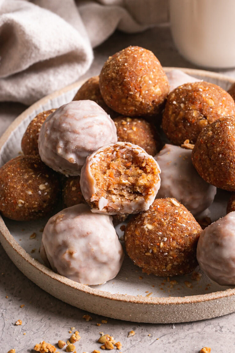 a bowl of carrot cake granola bites with one of them taken a bite out of it