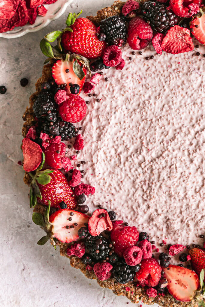 close up of breakfast chia yogurt granola tart decorated with fresh berries