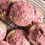 a close up of a round wire cooling rack with round cherry pop tarts overlapping on top.
