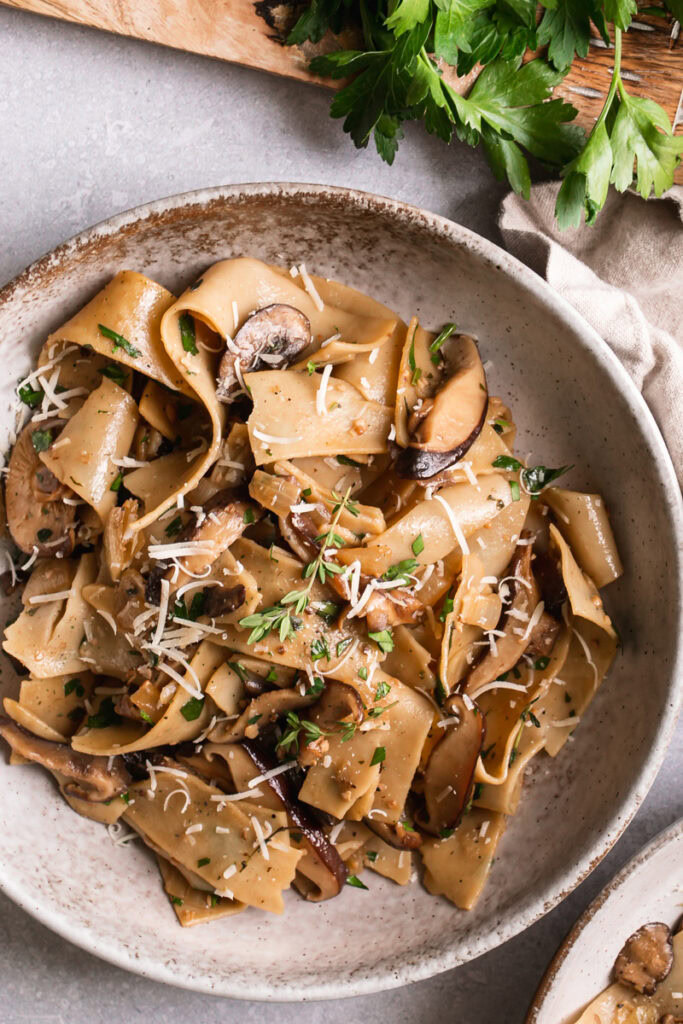 a close up of gluten-free pappardelle with wile mushroom Ragù in a bowl.