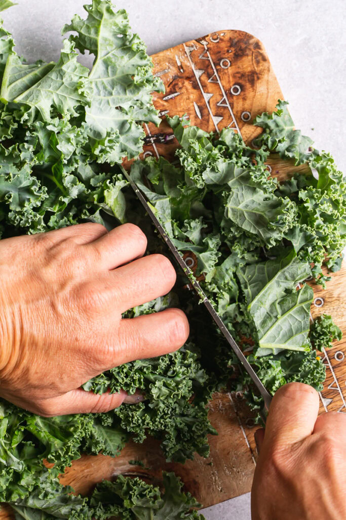 action shot of chopping kale on a cutting board with a Calphalon knife