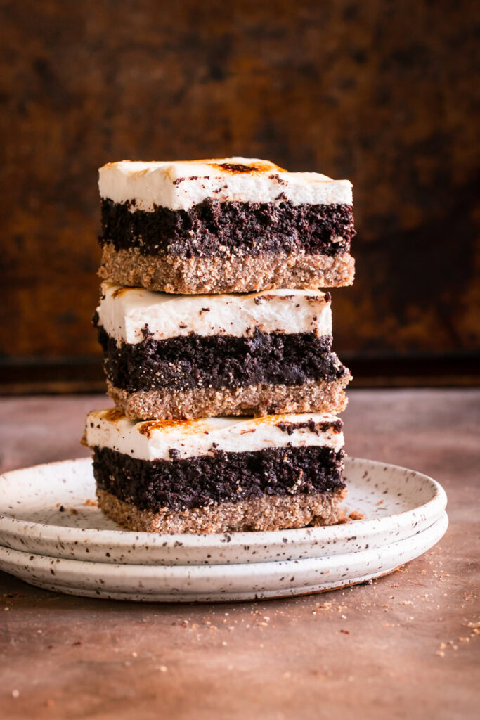 three s'mores brownies stacked on top of one another on a plate