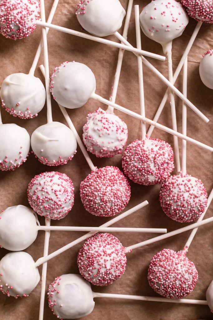 overhead shot of cherry cake pops layed out on a parchment-lined baking sheet