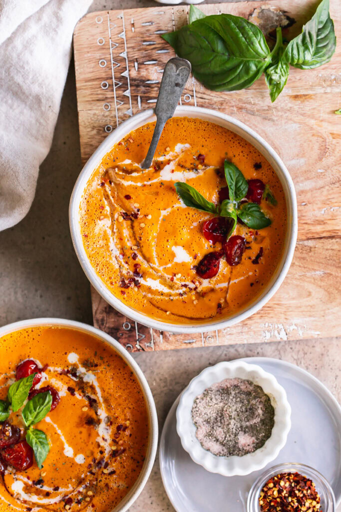 two bowls of roasted creamy tomato carrot soup