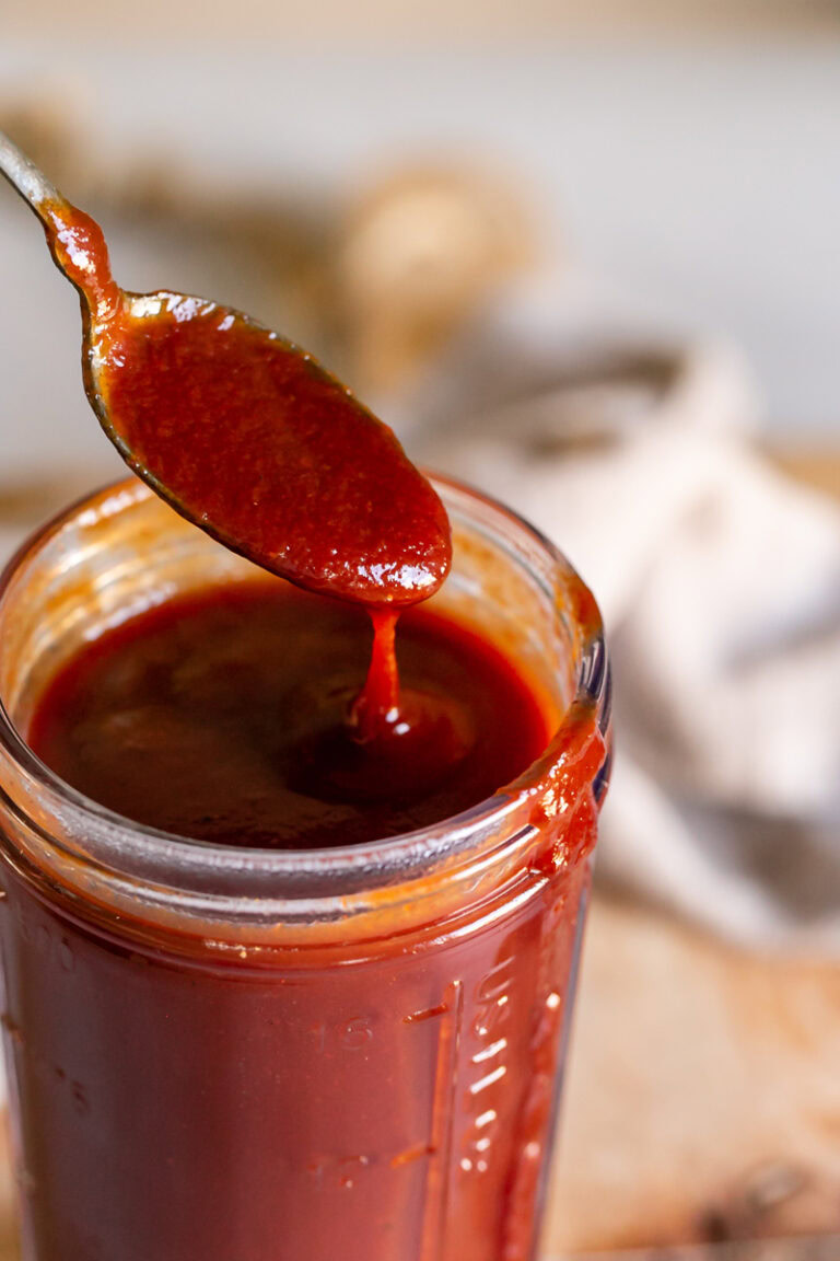 a close up 3/4 shot of bbq sauce dripping off a spoon