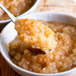 a bowl of Golden Delicious Applesauce with a spoon scooping some out