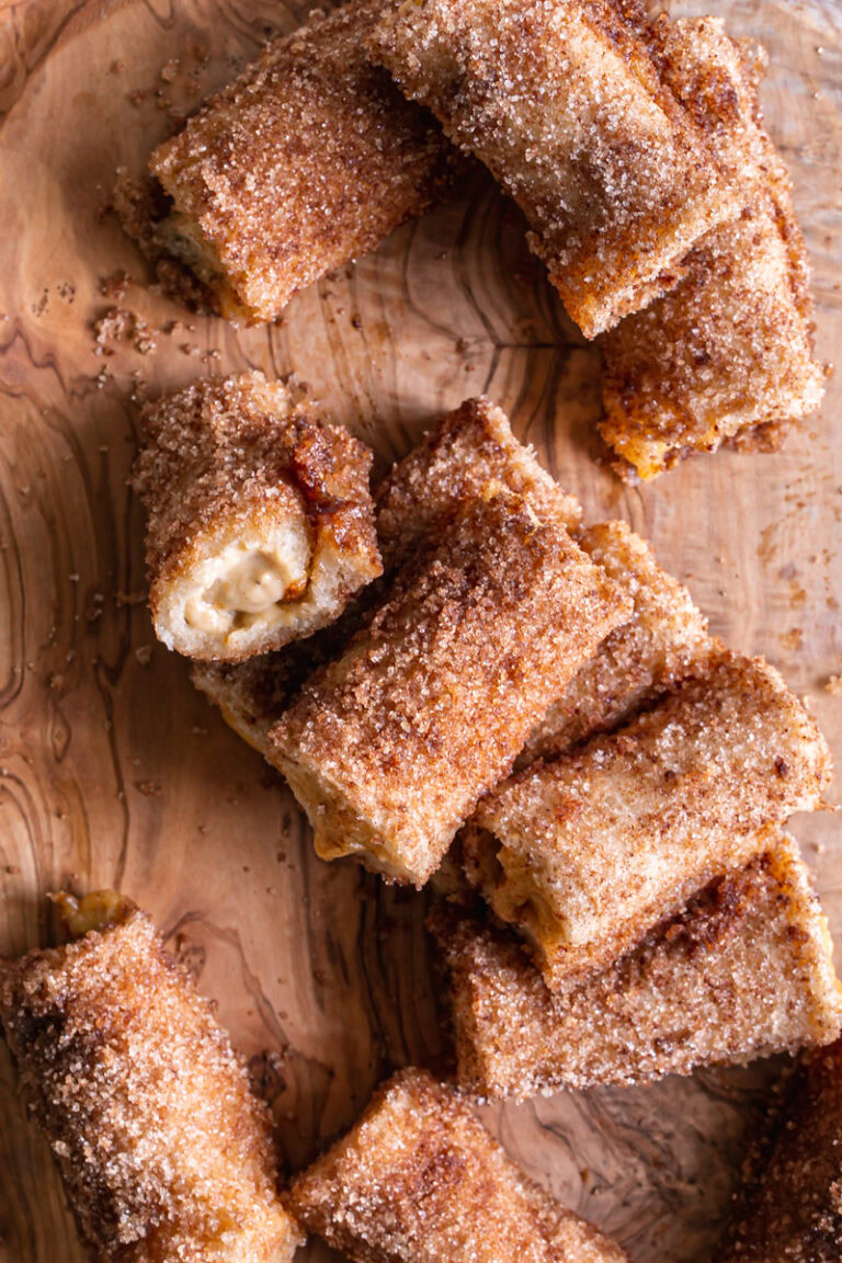 Overhead shot of Pumpkin Cream Cheese Rollups tossed on top of each other on a cutting board