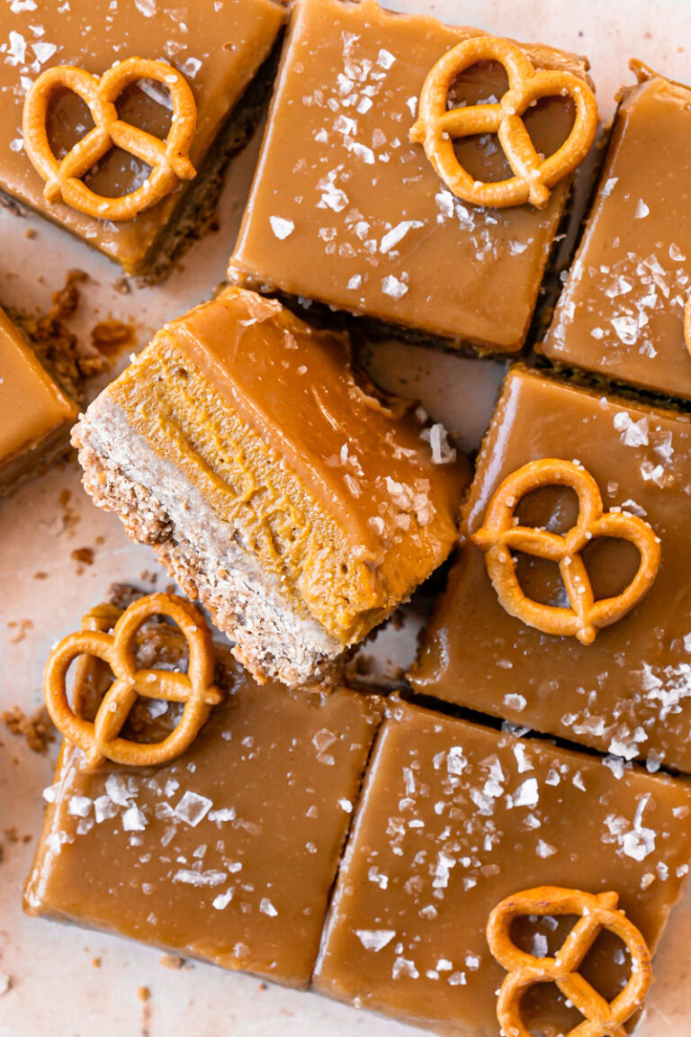 a close up overhead shot of sliced Salted Caramel Pumpkin Pie Bars, the middle one flipped on its side to reveal the pumpkin filling
