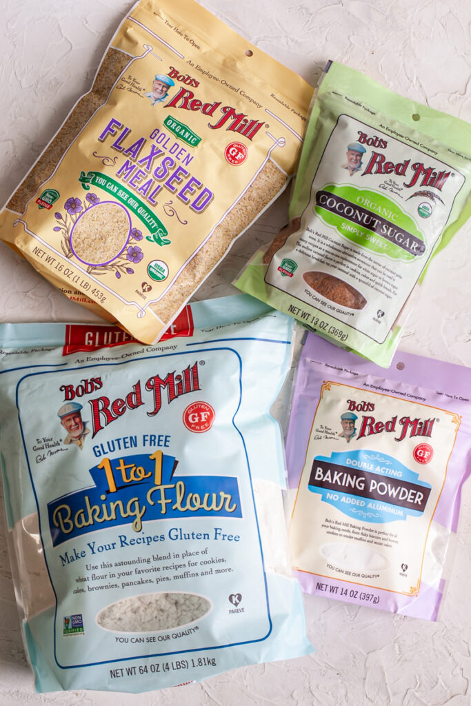 a bag of bob's red mill gluten-free 1-to-1 baking flour, a bag of bob's red mill organic golden flaxseed meal, coconut sugar, and baking powder