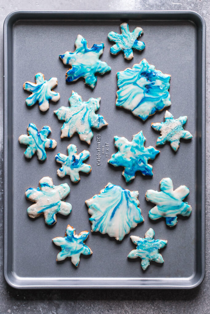 blue and white decoratedgrain-free marbled snowflake sugar cookies on a Calphalon baking sheet 