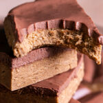 close up of stacked four seed homemade vegan protein bars, the top one with a bite taken out of it