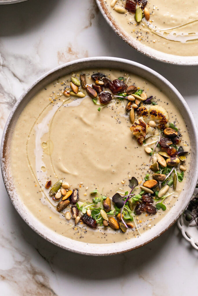 a flat lay close up shot of a bowl of roasted cauliflower soup