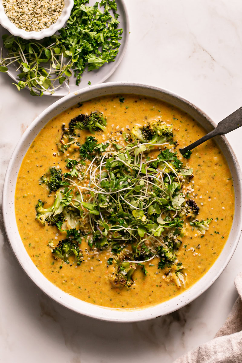 a close up overhead shot of Roasted Broccoli Potato Cheese Soup with a spoon in it