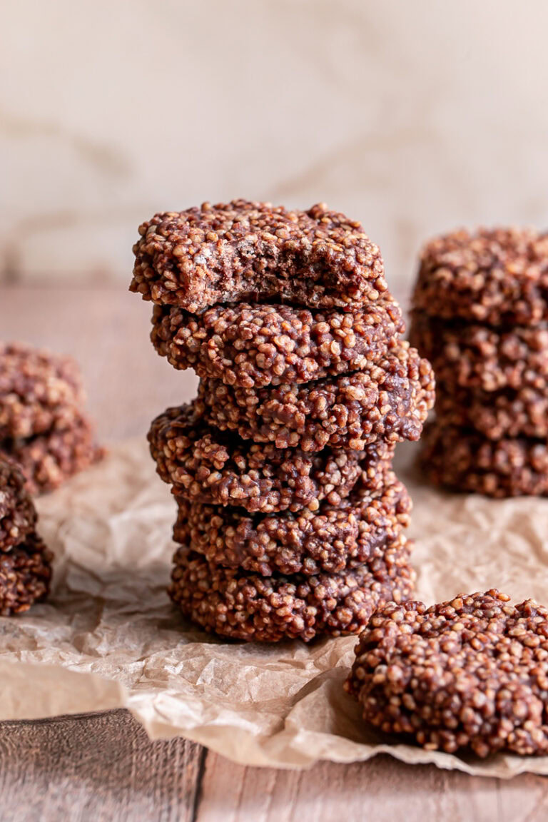 Crispy Quinoa Cacao Cookies stacked on top of one another, the top one with a bite taken out of it
