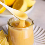 action shot of spooning some lemon curd out of the jar