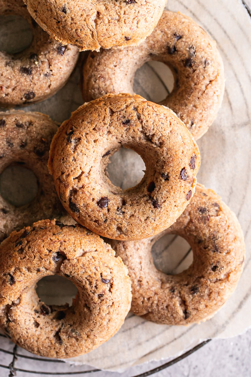 grain-free banana bread donuts piled on a round wire cooling rack