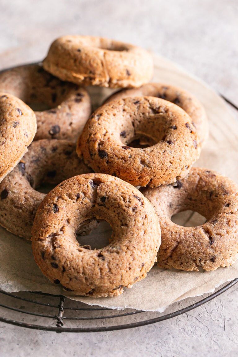 grain-free banana bread donuts piled on a round wire cooling rack
