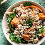 close up of a bowl of Protein Packed Creamy Tahini Quinoa Bowl on a green backdrop