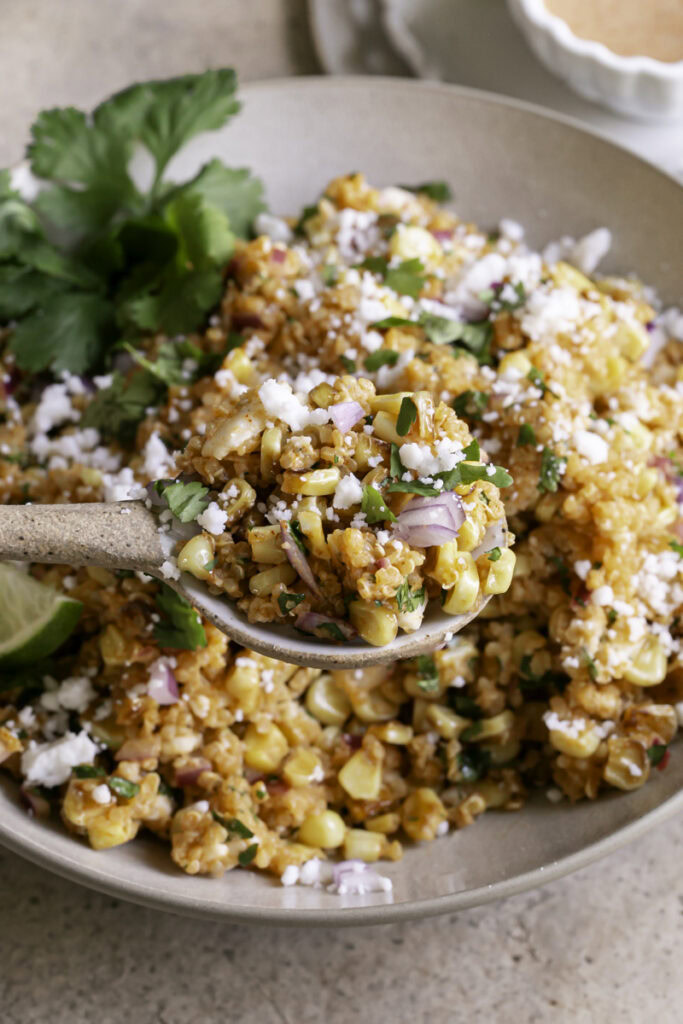 close up 3/4 view of scooping a spoonful of Dairy-Free Mexican Street Corn Quinoa Salad out of the bowl.