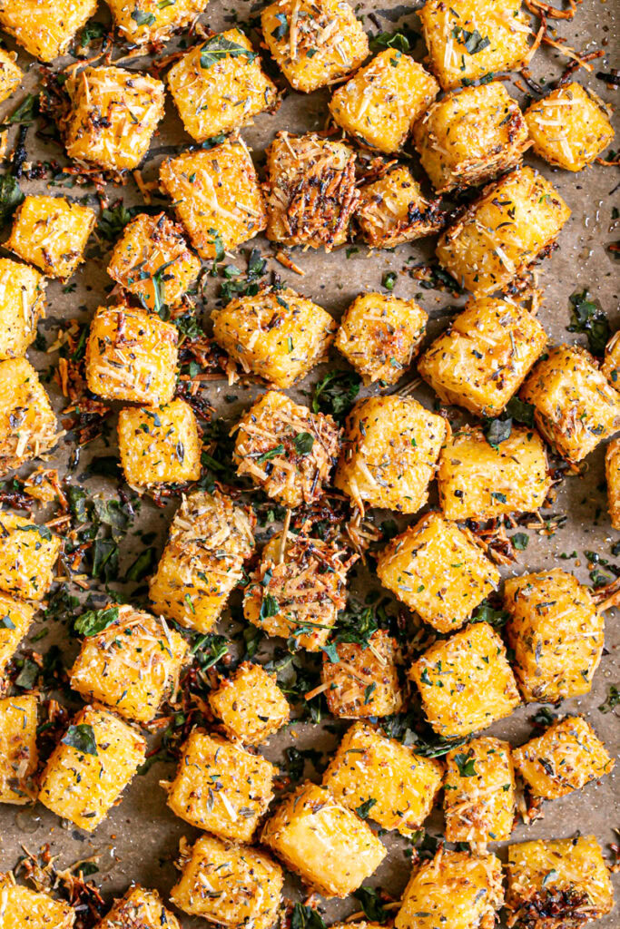 polenta croutons cooked on a baking sheet lined with parchment paper