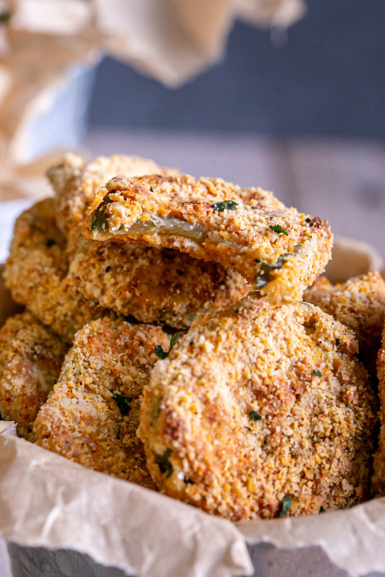 close up of air fried pickles with a bite out of the top one