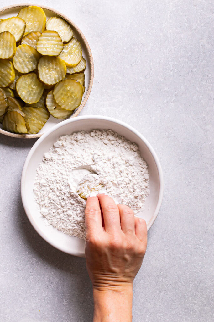 coating a pickle slice in gluten-free flour