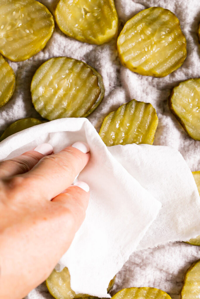photo of drying off the pickle sliced with a paper towel