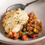 3/4 close up shot of over head shot of Vegan Gluten-Free Shepherd's Pie in a pie baking dish with some spooned into a bowl