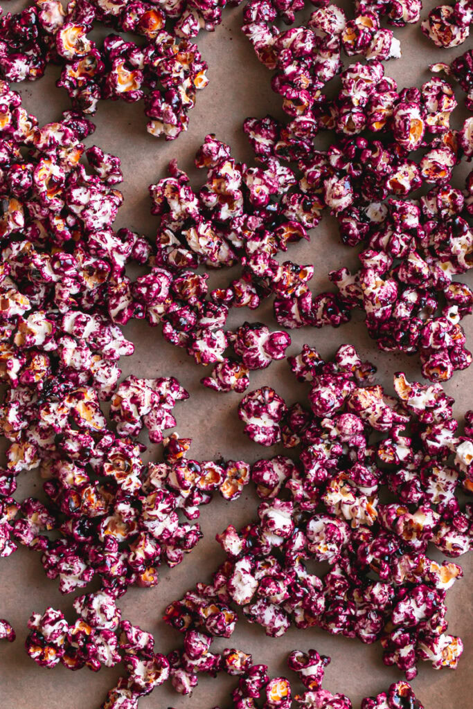 Candied Haskap Berry Popcorn spread out on a baking sheet