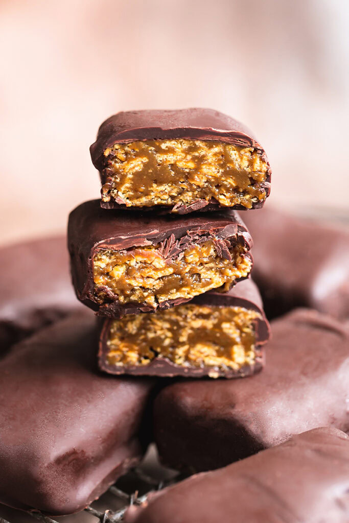 three Vegan Butterfinger Bars cut in half stacked on top of one another to reveal the filling