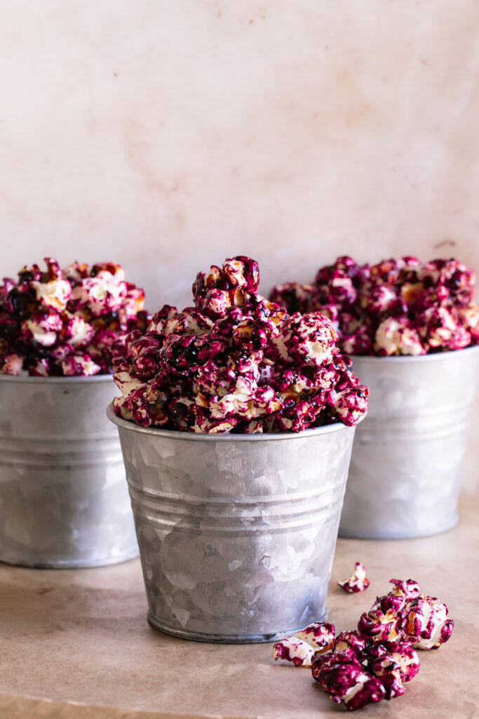 three small buckets filled with candied haskap berry popcorn