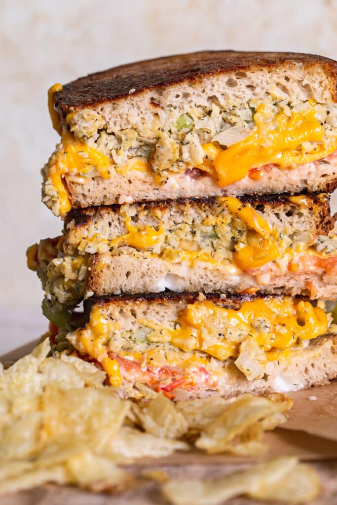 close up shot of three vegan tuna melt sandwich halves stacked on top of one another