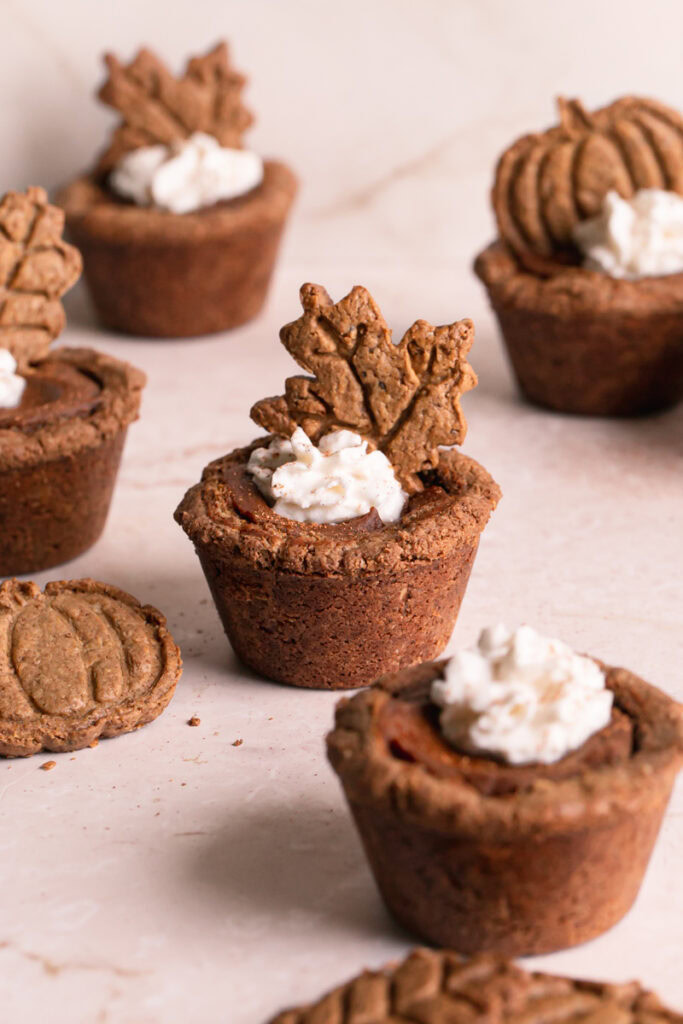 pumpkin pie cookie cups decorated with whipped cream and the fall cookies