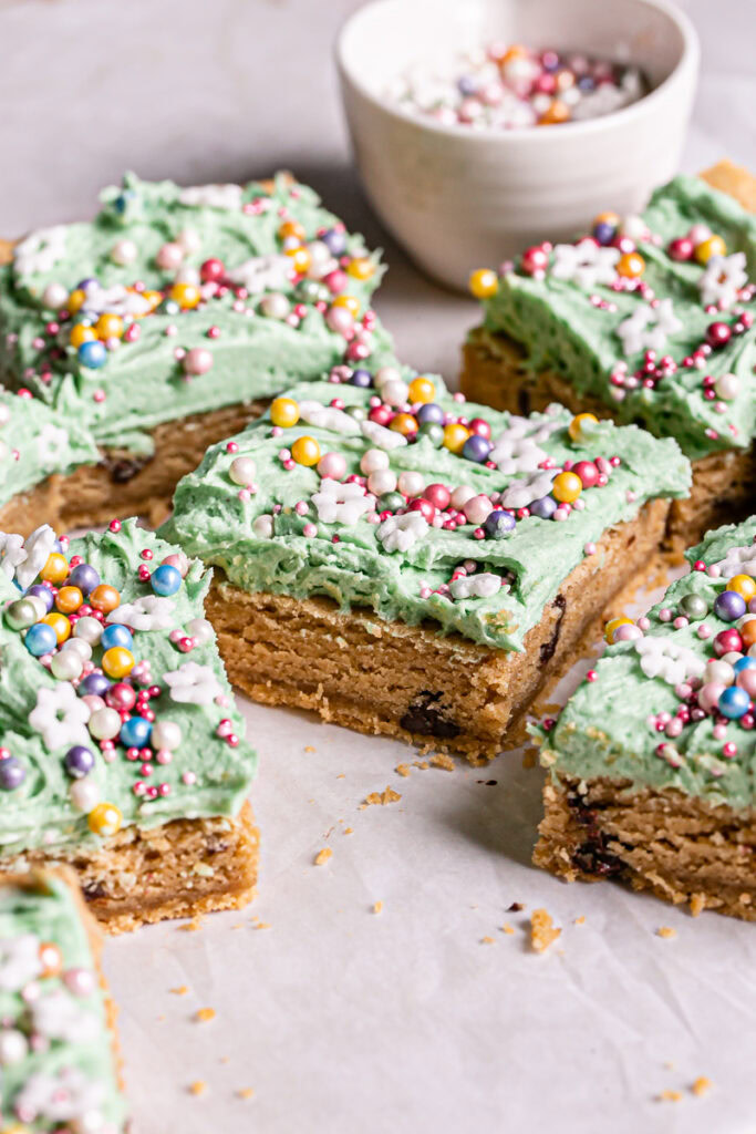 3/4 shot of vegan gluten-free green frosted cookie dough bars decorated with sprinkles