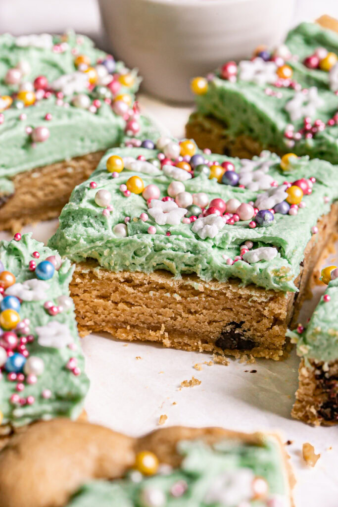 3/4 shot of vegan gluten-free green frosted cookie dough bars decorated with sprinkles