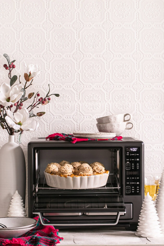 Calphalon air fryer oven open with a vegan chicken pot pie casserole sticking out with holiday decorations around the oven