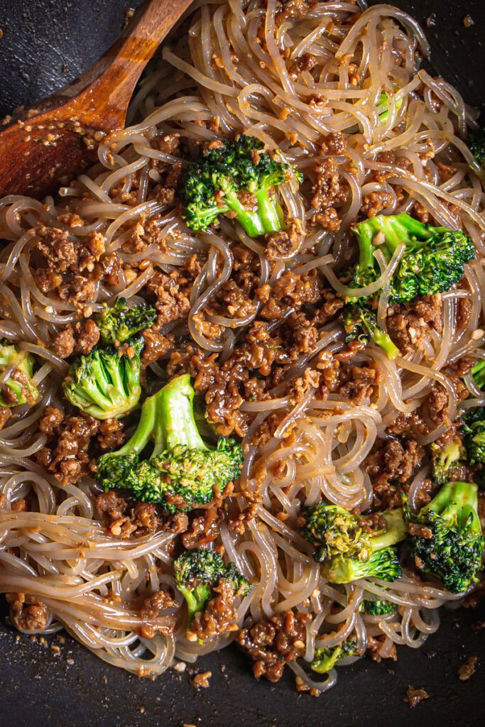 beef, broccoli and gluten-free glass noodles in a wok cooking