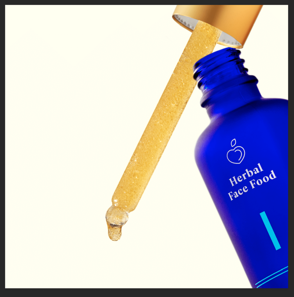 a close up of herbal face food bottle serum 1 with the dropper out of the bottle dripping a drop of serum