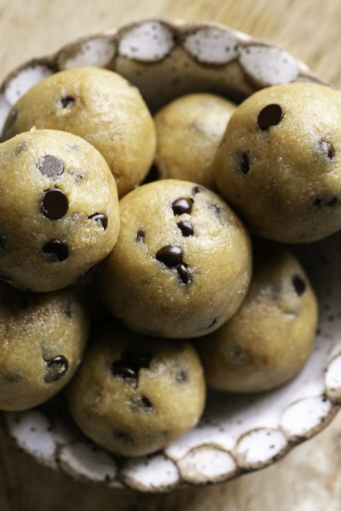 overhead shot of almond flour chocolate chip cookie dough bites in a bowl.