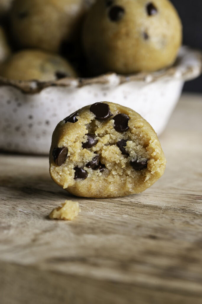 An almond flour chocolate chip cookie dough bite with a bite taken out of it.