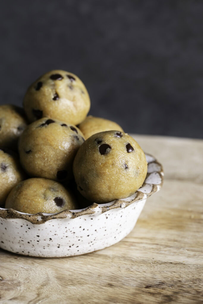 close up image of a bowl of a bowl of almond flour chocolate chip cookie dough bites.