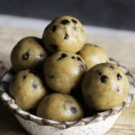 close up image of a bowl of a bowl of almond flour chocolate chip cookie dough bites.