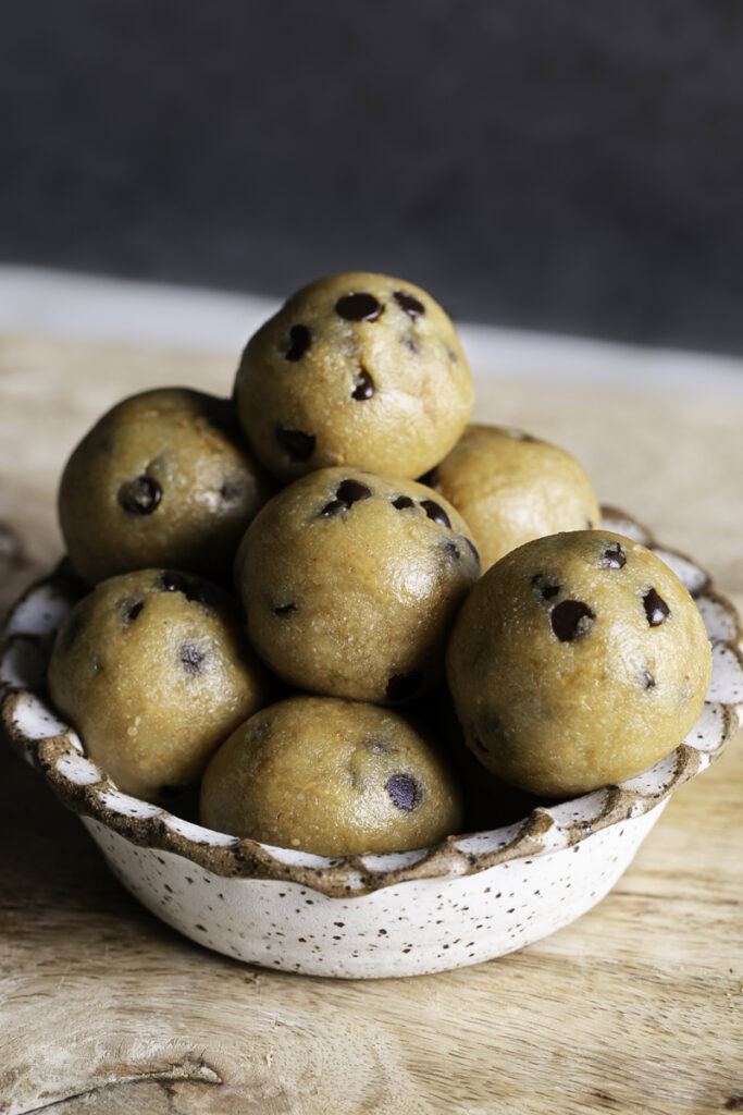 close up image of a bowl of a bowl of almond flour chocolate chip cookie dough bites.